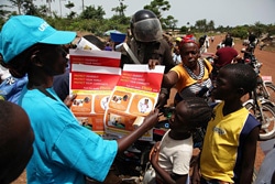 エボラに感染した際の対処法が描かれたポスターを配るスタッフ。（リベリア）