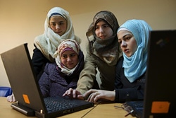 コンピュータの使い方を学ぶ女の子たち。（シリア）