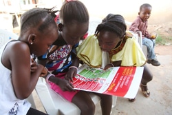 エボラの予防法に関するポスターを見る女の子たち。（リベリア）