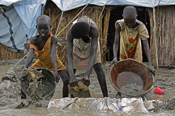 浸水を防ぐために泥で作った壁の外に水をかき出す子どもたち。（南スーダン）