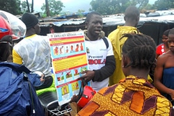 カイラフンで住民にエボラの症状や予防法を伝えるスタッフ。（シエラレオネ）