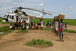 上ナイル州の町Kiech Konにヘリコプターで空輸された食糧などの支援物資を運ぶ女性たち。（南スーダン）
