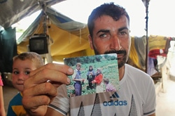 農場で働く家族の写真を見せるムハンマドさん。農作業中に爆撃に遭い、妻や兄弟を失った。（シリア）