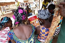 ユニセフが市場で配布したエボラの啓発用ポスターを読む住民。（リベリア）