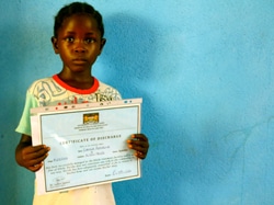 エボラ出血熱から回復したという証明書を見せるローズちゃん（5歳）。兄以外の家族全員がエボラに感染し、両親が亡くなって孤児となってしまった。（シエラレオネ）