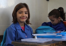 新しい通学かばんと文房具をもらった3年生の女の子。（シリア）