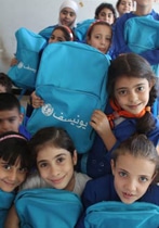 ダマスカス中心部で、新しい通学かばんをもらい、笑顔を浮かべる女の子たち。ユニセフは100万人以上の子どもたちに学用品を提供した。（シリア）