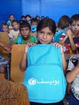 文房具などが入った通学かばんを見せるヌーランちゃん（9歳）。（シリア）