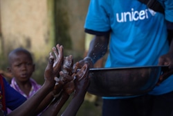 エボラ出血熱の啓発活動で、子どもたちにせっけんを使った正しい手洗いの方法を教える様子。（ギニア）