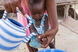 お母さんと一緒に手を洗う1歳3カ月の赤ちゃん。（チャド）