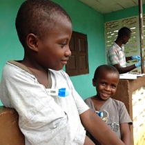 エボラから回復し、治療センターで最後の体温検査を受ける9歳と6歳の兄弟。（シエラレオネ）