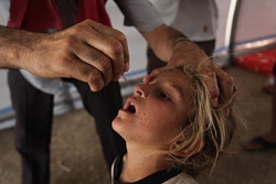 難民キャンプでポリオの予防接種を受ける女の子。（イラク）
