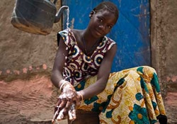 感染予防のため、石けんを使った正しい手洗いを友人に見せるマリエム・シディベさん。（14）