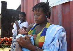 近くの保健施設が閉鎖され、赤ちゃんに予防接種を受けさせるため、予防接種所に並ぶ母親たち。（シエラレオネ）