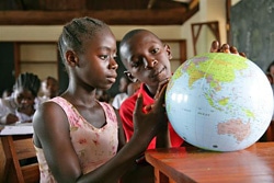 地球儀を見ながら勉強をする子どもたち。（リベリア）