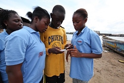 エボラの社会啓発活動に活用されている、U-Reportの使い方を教える若者たち。（リベリア）
