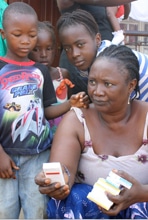 マラリアの予防薬を受け取った家族。（シエラレオネ）