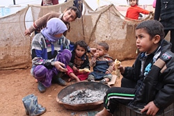 食事をするシリア難民の家族。