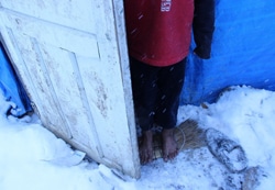 仮住居であるテントの入り口に裸足でたたずむ、トルコ・アンカラに身を寄せているシリア難民の7歳の男の子。