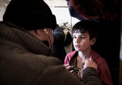 ベッカー高原で、子どもを診察する医師。