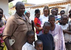 赤い服を着たグレースちゃん（2歳）を抱くエアブさん（18歳）と家族。