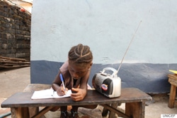 学校の閉鎖に伴って行われているラジオ教育を受ける女の子（6歳）。（シエラレオネ）
