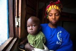母親をエボラで失った1歳半の男の子とケアセンターのスタッフ。（ギニア）