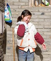 ルオ・イユンちゃん。被災後、ユニセフの支援を受けて設置された設置された給水ポンプを掃除している(中国)