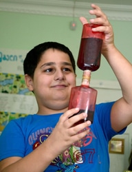 砂時計型のおもちゃで遊ぶ9歳の男の子。