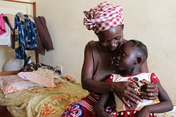 センターに身を寄せている5歳の女の子を抱きしめるカディさん。エボラ回復者はウイルスへの免疫があるため、子どもたちと防護服などなしで接することができる。