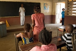 ギニアで再開された学校の様子（入口付近に立つ青木さん）