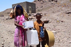 ユニセフの支援物資を受け取った親子。