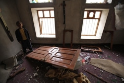 サナア近くの村の破壊された自宅を訪れた男の子。