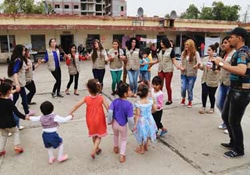 円になってダンスを踊る避難民の子どもたちや活動を支援する若者のリーダーたち。