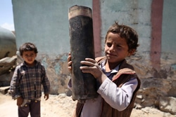 サナア郊外の村で、爆発した砲弾の破片を手にする男の子