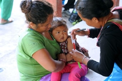 ボランティアの保健員が栄養状態の検査をする様子。