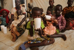 難民キャンプで栄養不良の子どもの治療ケアのための補助栄養素が入った飲み物を飲む子どもたち。