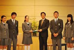 J7で作り上げたポジション・ペーパー（提案書）を安倍首相に手渡す日本代表の高校生たち。