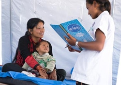 生後6カ月の娘を抱く24歳の母親とユニセフが支援する避難施設で話をする18歳の看護師。