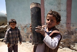 首都サヌアの近郊にある村で、爆発した砲弾の残骸を手にする男の子。