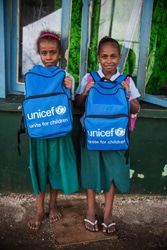 学用品が詰まったユニセフバッグを嬉しそうに持つバヌアツの女の子たち