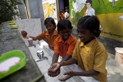 昼ごはんの前に手を洗うインドの児童たち