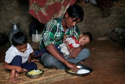 子どもたちに食べ物を食べさせる父親。