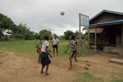 ズバールくんの村にある若者のための支援センターの前でボールを蹴って遊ぶ男の子たち。