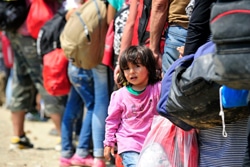 マケドニアのゲヴゲリアでセルビアへの電車を待つ列に並ぶシリア難民の子ども。