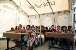 国内避難民のためのキャンプに設置されたテントの学校で授業を受ける子どもたち。（イラク）