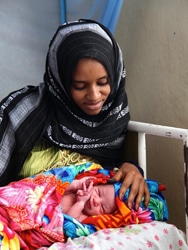 生まれたばかりの赤ちゃんを抱く母親。（エリトリア）