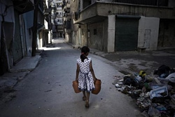 水を汲むための容器を持ってアレッポの町を歩く少女。