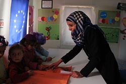 18歳のエメルさんは、ハラン難民キャンプで暮らすシリア難民。子どもにやさしい空間のボランティアとして、小さな子どもたちの面倒を見ている。