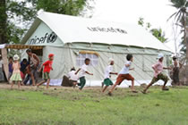 ユニセフ支援のスクールテントの外で遊び、学校に戻れることを喜ぶラプッタ地区内の村の子どもたち。ひとつのテントで50人の子どもたちが学ぶことができます。